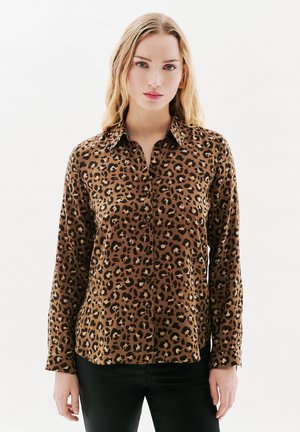 Chemise à boutons à imprimé léopard marron avec des manches longues, un col pointu et des boutons noirs. Tissu lisse avec une texture brillante.