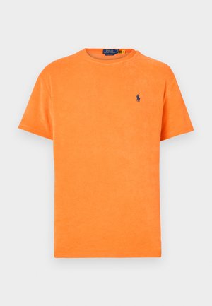 Ljusa orange kortärmad t-shirt i frottétyg med blå Polo Ralph Lauren-logotyp broderad på vänster bröst.