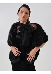 Châle en fausse fourrure noire au toucher lisse, orné d'un grand nœud noir au cou et d'un tissu noir transparent en dessous. Design simple et élégant.