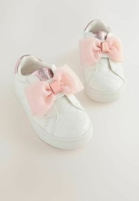 Valkoiset tennarit, joissa on vaaleanpunaiset nauhat, sisältäen teksturoidun kuvion ja sileän pinnan. Pyöristetyt varpaat ja kumipohjat pitävyyteen.