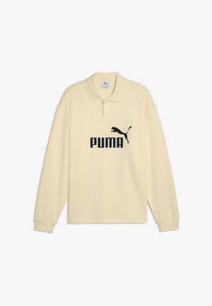Kremowa koszulka polo z długim rękawem, z czarnym logo Puma i tekstem na środku z przodu, z klasycznym kołnierzykiem i mankietami na rękawach.