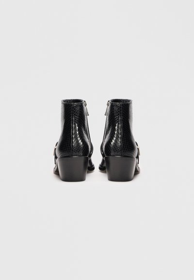 Cizme negre până la gleznă cu un finisaj texturat asemănător pielii de șarpe, având un detaliu cu fermoar la spate și un toc bloc moderat.