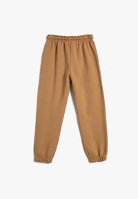 Pantalones de chándal de algodón marrón con cintura elástica, pierna ajustada y puños gatherizados. Textura suave con un color sólido, sin patrones.