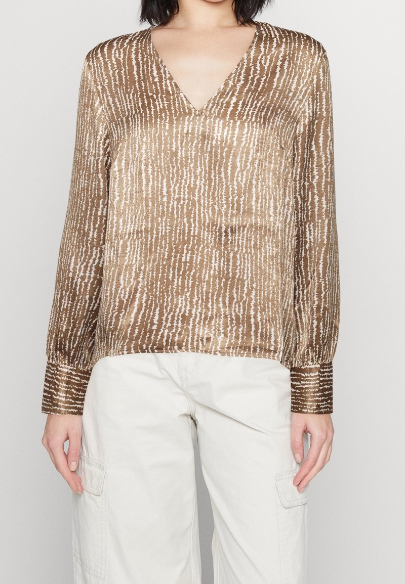 Blouse marron à manches longues avec un col en V ; présente un motif texturé de lignes verticales dans des tons plus clairs et des poignets élastiqués.