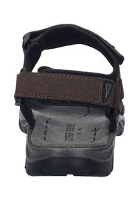 Brun sandal med justerbara remmar, vadderad sula och en texturerad gummisula. Har en robust och hållbar design.