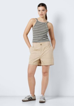 Shorts beiges avec deux poches avant, une fermeture à bouton à l'avant, et une coupe droite associés à un débardeur rayé noir et blanc.