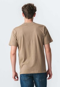 Brun bomulds T-shirt med korte ærmer og rund halsudskæring, vist fra ryggen. Stoffet ser glat ud med en afslappet pasform.
