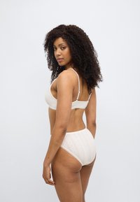 Σετ πολυτελών μπραλετέ από μπεζ βαμβάκι και εσώρουχο με ψηλή μέση, με υφασμένους μοτίβους και ρυθμιζόμενους ιμάντες, με ομαλή υφή.