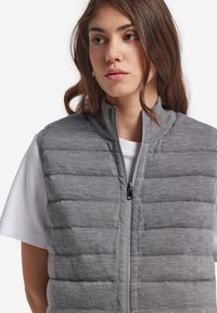 Szary, pikowany kamizelka z wysokim kołnierzem i zamkiem błyskawicznym z przodu. Wykonana z miękkiego materiału teksturowanego, z poziomymi wzorami przeszycia.