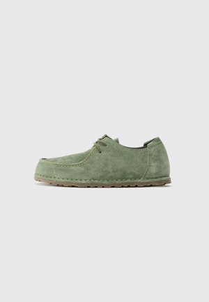 Green suede lace-up casual shoe with stitched detailing and brown rubber sole, shown in side profile on a plain background.