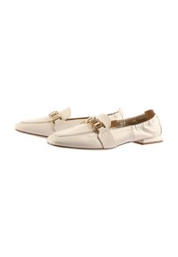 Mocassins en cuir blanc avec un bout pointu et un accent en chaîne dorée. Talon plat et dos élastiqué pour le confort. Texture lisse et design minimal.