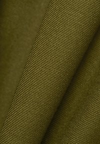 Tekstūruota alyvuogių žalios spalvos medžiaga su tankiu audimu, rodanti gilumą ir subtilius nuokrypius. Paviršius atrodo tvirtas ir patvarus.