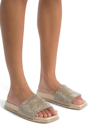 Infradito beige con un design piatto, impreziositi da scintillanti rhinestone e una texture liscia sulla parte superiore.