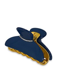 Pince à cheveux bleu marine avec une finition brillante, présentant une charnière dorée et un petit accent en strass le long du bord supérieur. Conçu en forme de griffe.