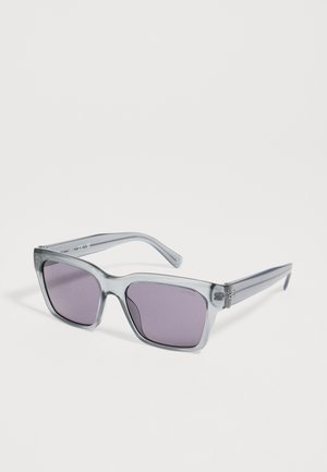 Grau-transparente, quadratische Sonnenbrille mit violett getönten Gläsern, so positioniert, dass Vorder- und Seitenansicht auf weißem Hintergrund zu sehen sind.