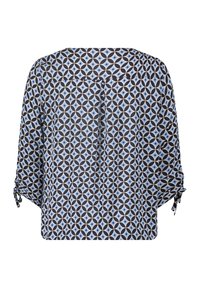 Chemisier fluide avec un motif géométrique en bleu et noir, fabriqué en tissu léger, avec des manches 3/4 à nouer et une coupe décontractée.