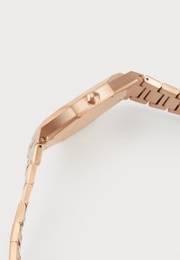 Rosa-goldfarbene achteckige Uhr mit einem glatten Metallgehäuse und einem verlinkten Armband. Texturierte Akzente und eine seitliche Krone runden das Design ab.