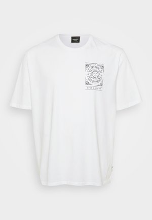 Balta kokvilnas T-kreklā ar īsām piedurknēm, kurā uz kreisā krūšu apgabala ir melns grafiskais prints ar ģeometriskām un saules motīviem.