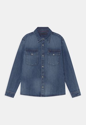 Denimhemd in mittlerem Blau, lange Ärmel, Knopfleiste, zwei Brusttaschen mit Klappen, weicher Stoff und leicht verblasster Optik.