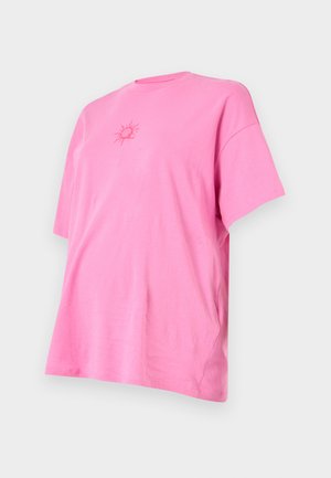 Camiseta de algodón rosa con mangas cortas, corte relajado y un gráfico de sol en el centro. Textura suave con un diseño de cuello redondo.