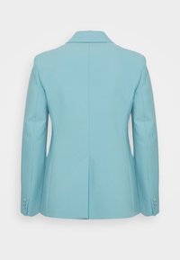 Giacca azzurro chiaro con design strutturato, rever appuntiti, maniche lunghe e quattro bottoni sui polsini. Presenta una spacco centrale sul retro.