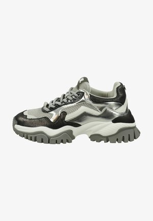 Sneaker épais avec un design en argent métallique et noir, tige en maille, lacets gris et semelle en caoutchouc texturée présentant des motifs de crampons prononcés.