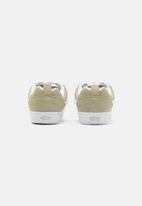 Tan suede sneakers with white accents, padded collar, and a cream rubber sole. Features "VANS OFF THE WALL" logo on the heel.