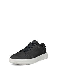 Μαύρα δερμάτινα αθλητικά παπούτσια με υφασμένη υφή, στρογγυλή μύτη, λευκή λαστιχένια σόλα και σκουρομπλε κορδόνια. Διαθέτουν χαμηλή κατασκευή και ελάχιστες λεπτομέρειες.