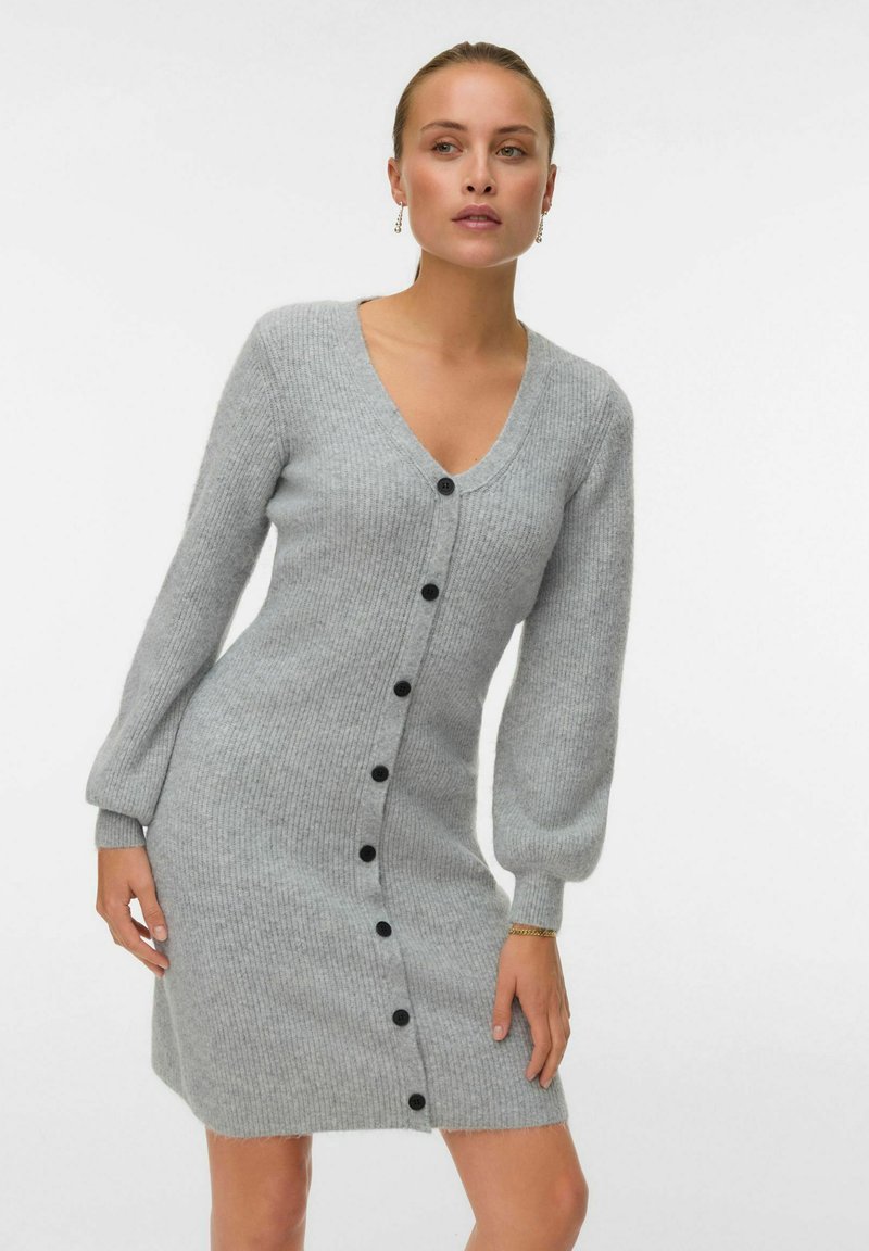 Abito grigio lavorato a maglia con scollo a V e lunghe maniche a sbuffo, dotato di bottoni neri lungo la parte anteriore e una texture leggermente pelosa.