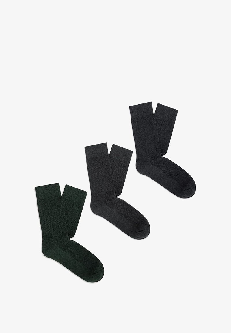 Trzy pary skarpetek: jedna w ciemnej zieleni i dwie w odcieniach ciemnoszarego. Materiał wydaje się teksturowany z prążkowanym wzorem w górnej części.