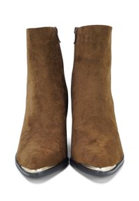 Bruine suède enkelboots met een spitse neus en zilveren accent op de neus, voorzien van een ritssluiting aan de achterkant. Gladde textuur.