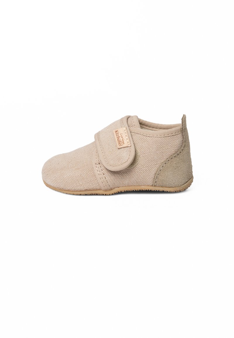 Lichtbeige babyschoen van textuurstof met een klittenbandsluiting en zachte suède accenten, voorzien van een flexibele rubberen buitenzool.