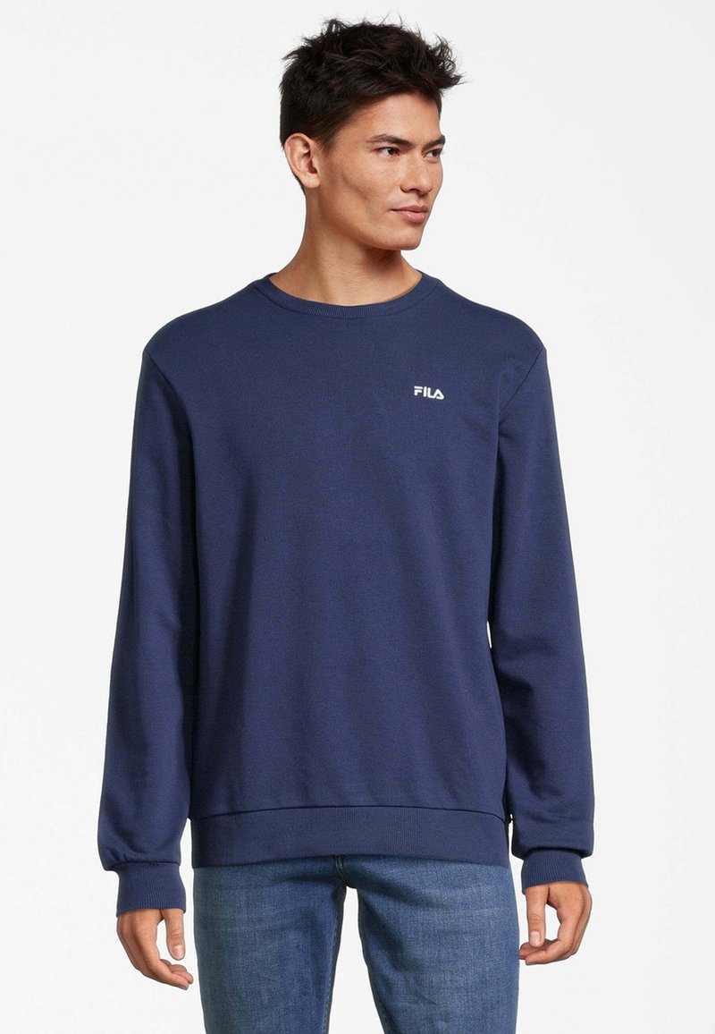 Felpa blu navy con maniche lunghe, polsini a costine e scollatura a girocollo. Presenta un logo FILA bianco sul petto. Texture liscia.