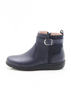 Bottes chevilles bleu foncé en cuir texturé. Les caractéristiques incluent une boucle en métal argenté au niveau de la cheville et une semelle en caoutchouc texturé et basse.