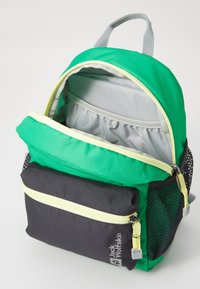 Green backpack with a grey interior, black front pocket, and yellow accents. Features zippers, mesh side panel, and a top handle.