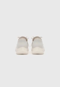 Light gray athletic shoes with a mesh upper, rounded heel, and soft rubber sole. Features minimalistic design and tonal laces.