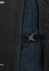Zaino nero e blu realizzato in tessuto spesso e resistente, con una superficie testurizzata, una tracolla regolabile e una chiusura a fibbia in plastica.