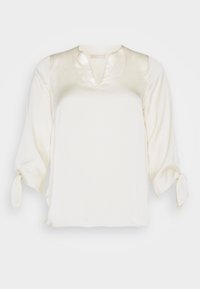 Weiße Bluse mit V-Ausschnitt und Dreiviertelärmeln, die Krawattendetails an den Manschetten und einen dezenten strukturierten Stoff aufweist.