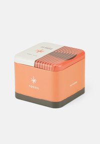 Quadratische Zinnbox in Orange und Creme. Mit einem geometrischen Muster auf dem Deckel und einer glatten Oberfläche. Das "FOSSIL"-Logo ist deutlich sichtbar.