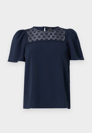 Navy blue short-sleeve top with a textured body and a lace panel at the neckline. Back button closure, slightly puffed sleeves.