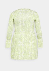 Vestido de manga longa em verde claro com padrões florais e geométricos brancos. Tecido suave, formato ajustado, decote redondo, design até aos joelhos.