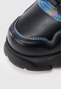 Fekete bőrből készült sportcipő texturált gumitalppal. Többszínű mintás díszítéssel a fűzők közelében és kontrasztos varrási részletekkel rendelkezik.