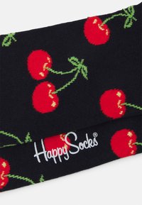 Juodos kojinės su vyšnių raštu raudonos ir žalios spalvos, su "Happy Socks" logotipu baltu ant viršaus. Minkšta, mezgimo tekstūra.