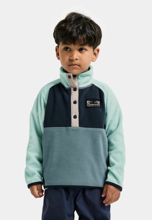 Fleece pullover i mintgrøn og marineblå med høj krave, knaplukning og logo-patch på brystet. Blød tekstur.