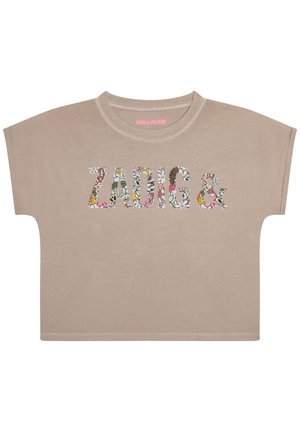 Chemise beige à manches courtes avec le texte ""ZADIG &"" en motif floral sur la poitrine et un col rond.