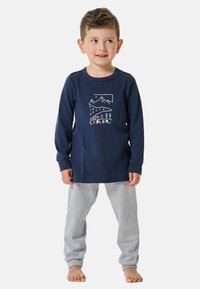 Marineblaues Langarmshirt mit "EXPLORE" Grafik und Bergdesign, kombiniert mit grauen Sweatpants, beide aus weichem, atmungsaktivem Material.