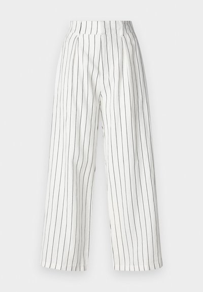 Pantalon large blanc avec des rayures verticales noires, taille haute et tissu doux avec une finition légèrement texturée.