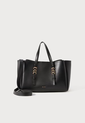 Sac fourre-tout en cuir noir avec deux poignées et une bandoulière amovible. Accents en métal doré et base plate pour plus de stabilité.