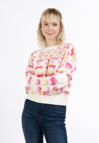 Bunt gemusterter Pullover mit pinken und gelben Herzformen, aus weichem Material gefertigt, mit Rundhalsausschnitt und gerippten Bündchen.