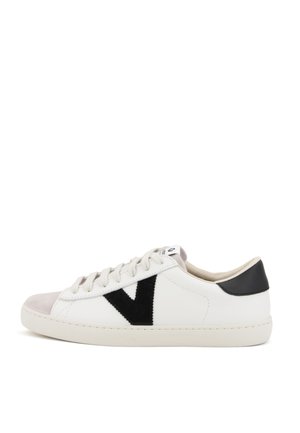 Zapatilla blanca de cuero con puntera de ante gris, logo en ante negro y lengüeta trasera negra. Cuenta con cordones redondos, forro textil y suela de goma.